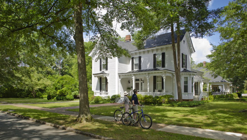 Couple stops their bicycles to admire historic homes.