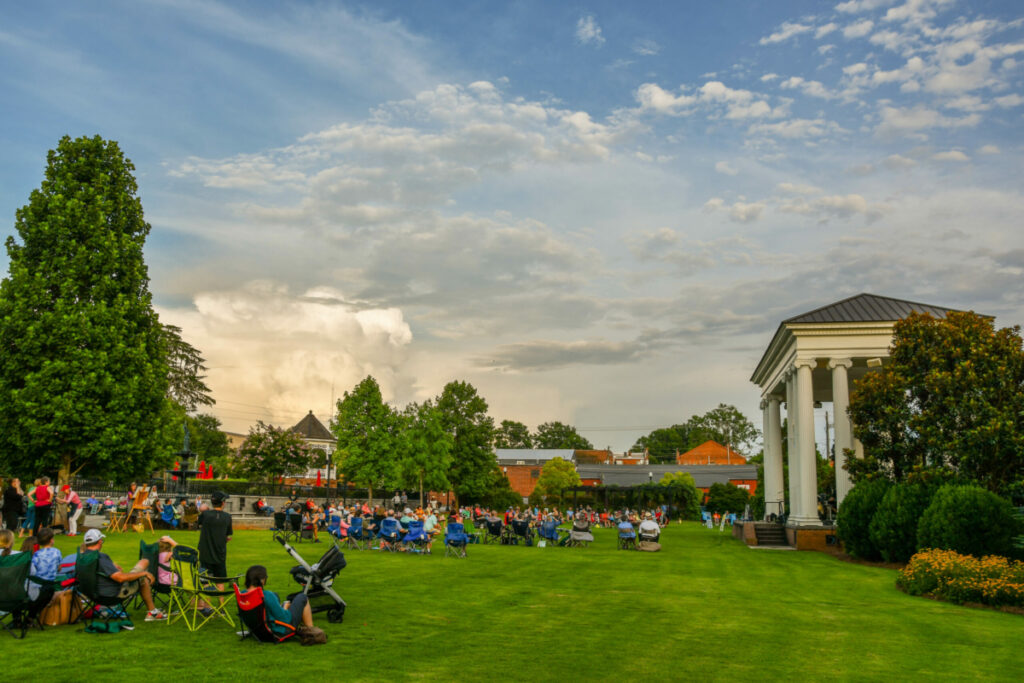"People in lawn chairs listening to music in Town Park."