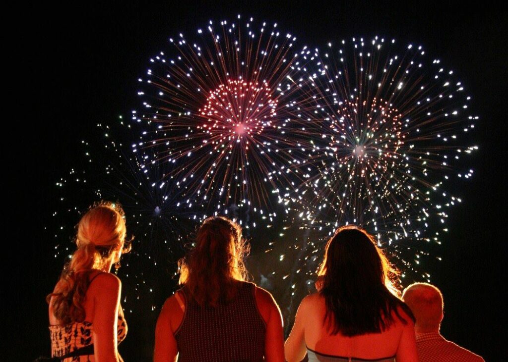 "Friends watching fireworks in the night sky."