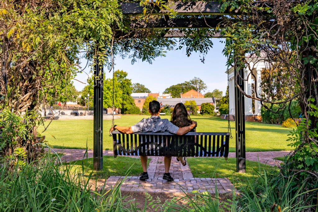 Couple sitting on a swing surrounded by flowers in Madison Georgia