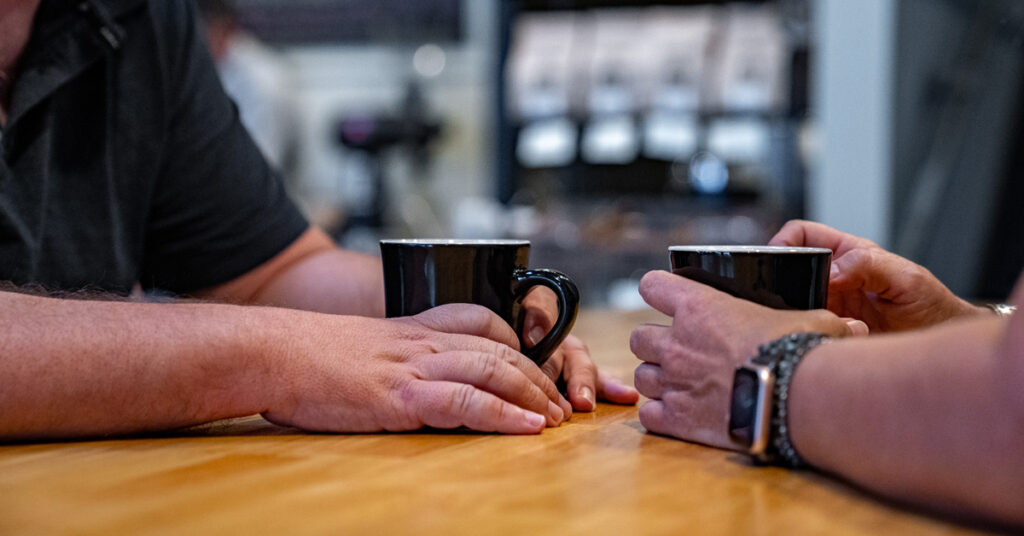 Couple holding hands at Oconee Coffee Roasters in Madison, GA