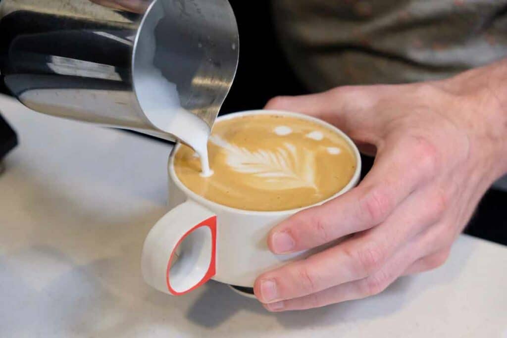 Pouring a milk design on a coffee at Oconee Coffee Roasters